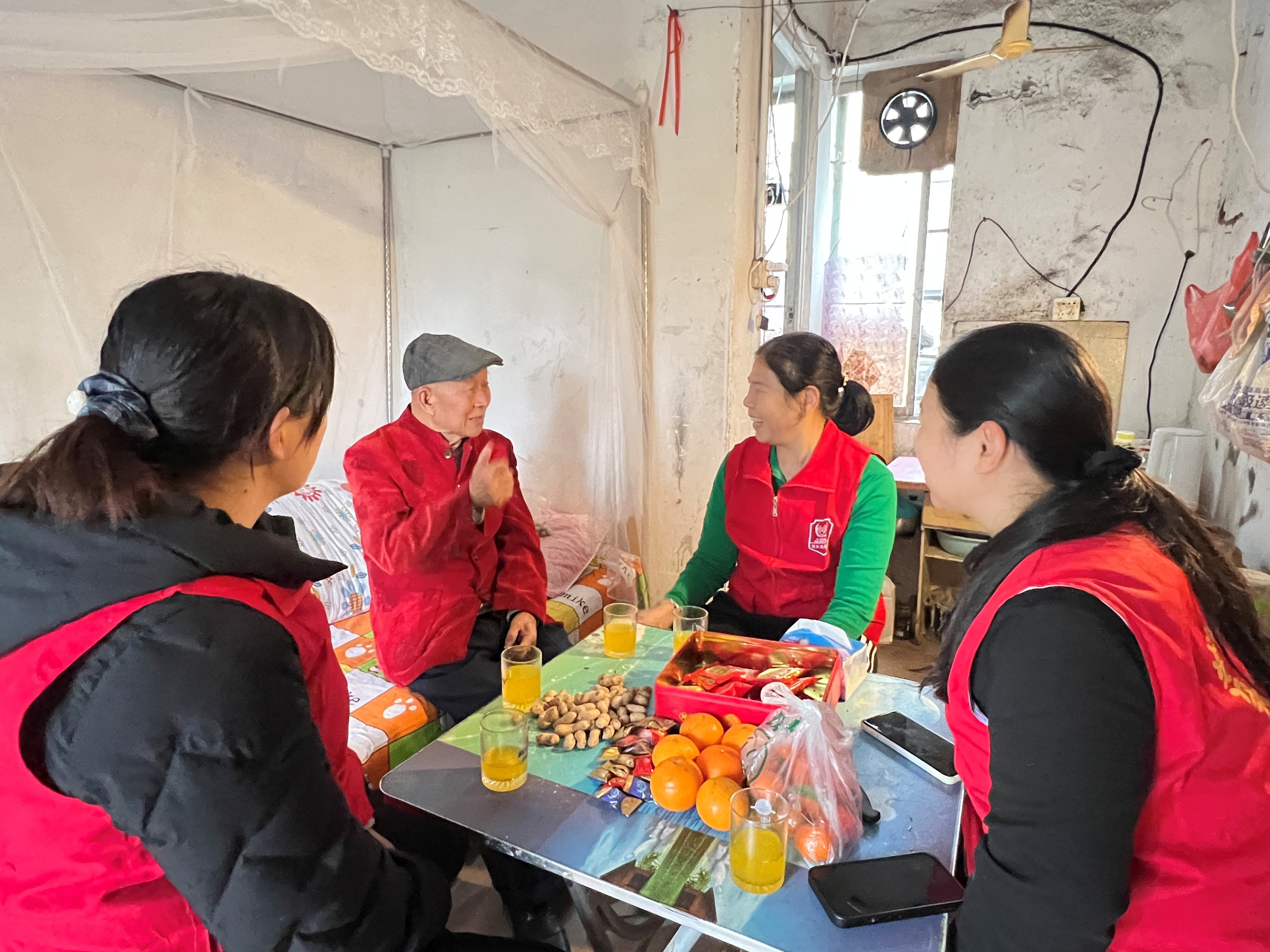 社区工作人员元宵节上门慰问独居长者并与之聊天，现场欢声笑语一片