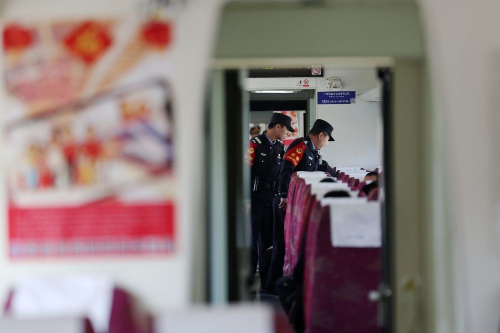 3月11日，兰州铁路公安处乘警支队民警段文革（右）和王岳宁在兰州开往上海的T118次列车上核对旅客信息。新华社记者　陈斌　摄