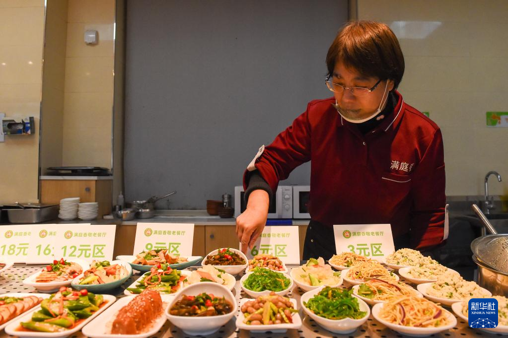 3月6日,工作人员在长春市朝阳区杏花邨社区满庭香敬老餐厅摆放菜品。
