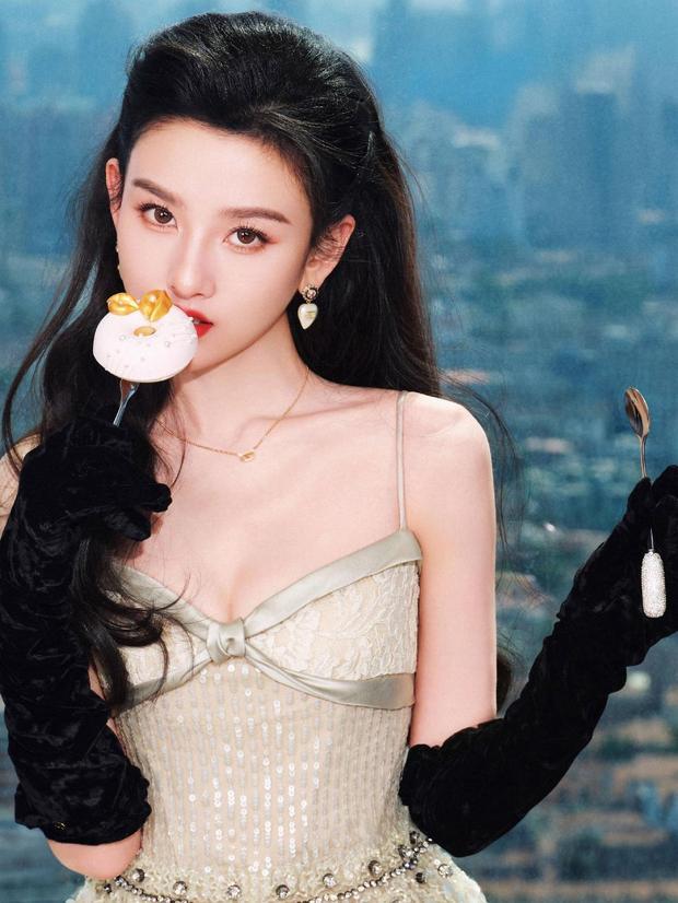 宋祖儿佩戴珍珠耳饰，手拿甜甜圈，红唇明艳。