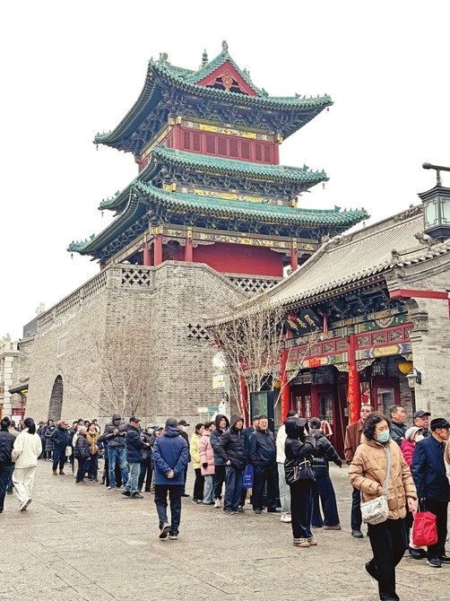 2月28日,雄伟的钟楼下,市民排队购物。柴子贤摄