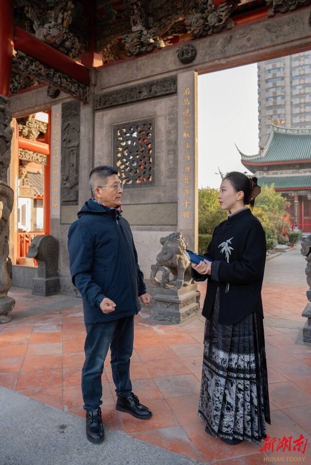 烟台福建会馆内,李日(左)为湖南日报全媒体记者解联。