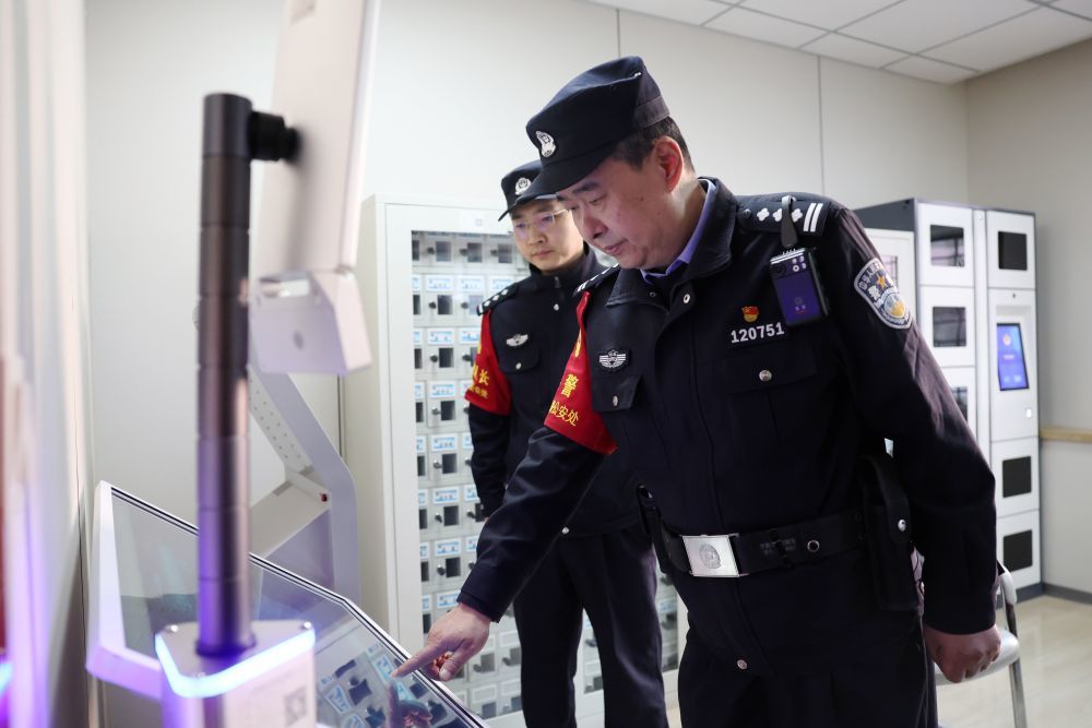 3月11日，兰州铁路公安处乘警支队民警段文革（右）在最后一次值乘前通过智慧乘务系统打卡。新华社记者　陈斌　摄