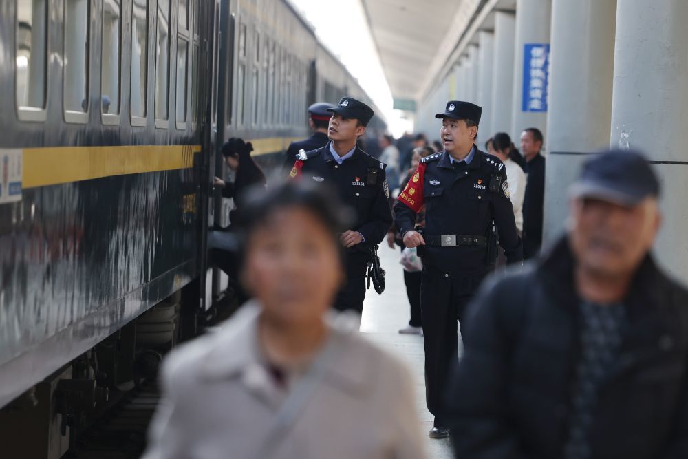 3月11日，兰州铁路公安处乘警支队民警段文革（右）和王岳宁在兰州火车站站台上巡查。新华社记者　陈斌　摄