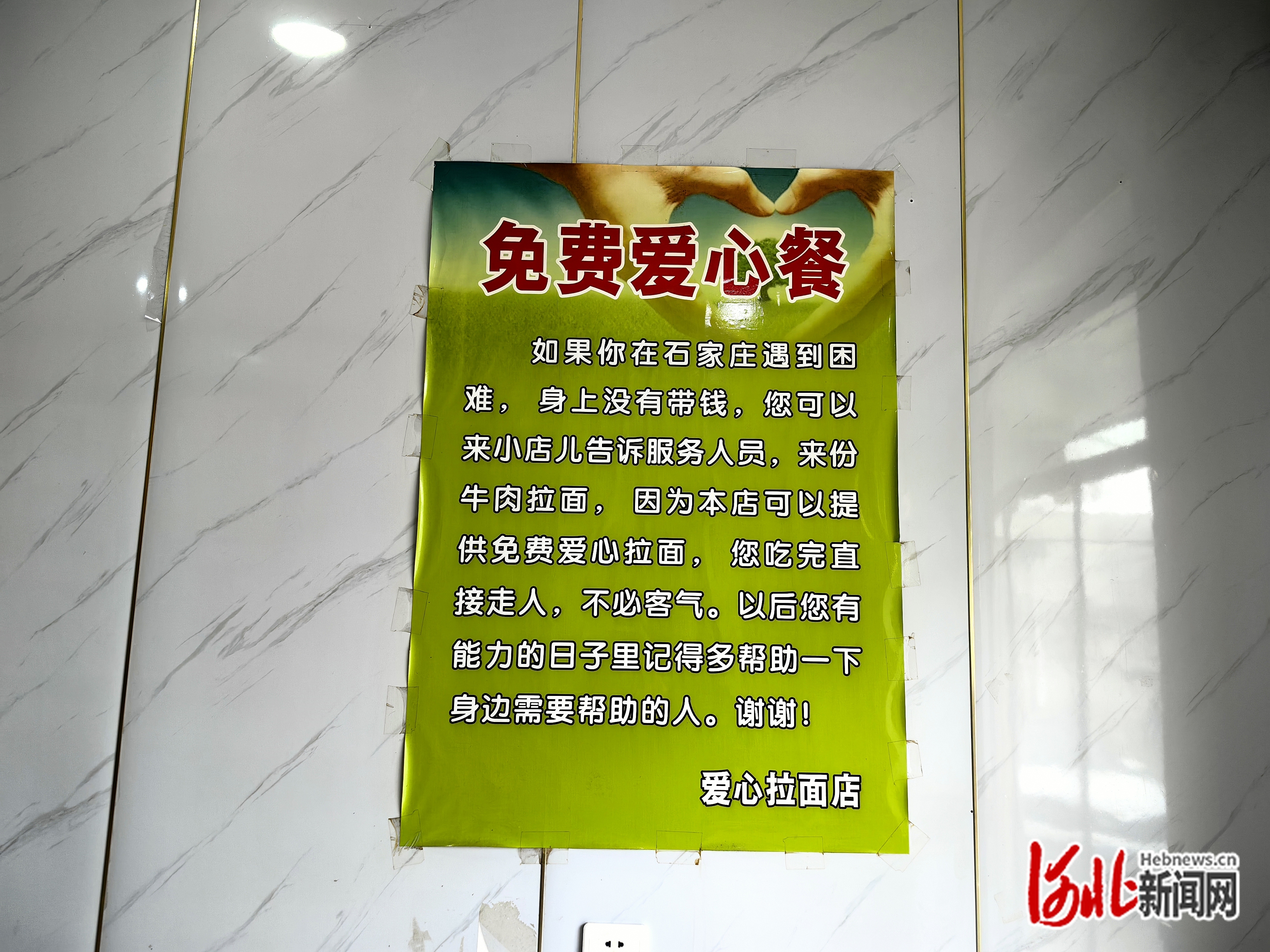 店里贴着“免费爱心餐”的海报。袁欣悦摄
