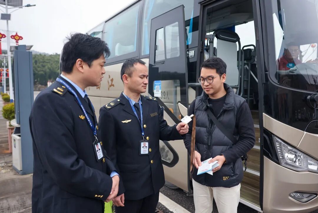 执法人员在万年神农宫景区检查旅游大巴，核对导游证件、行程单等。