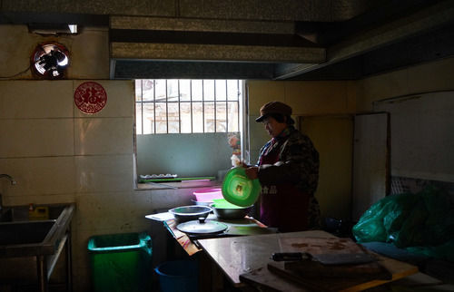客人走后，熊庚香在厨房内清洗餐具。