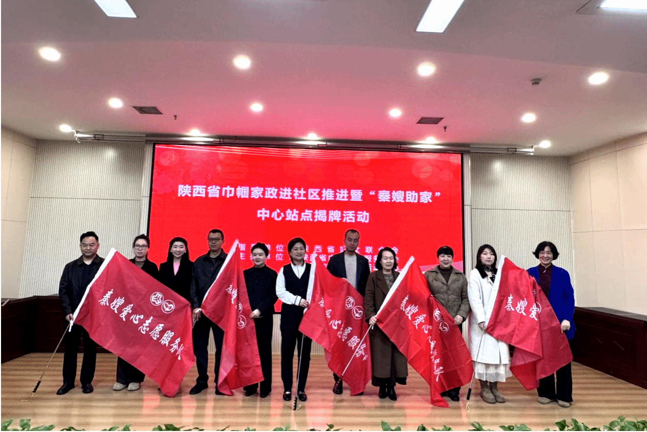 西安培华学院工会主席陈玲(左二)等嘉宾为巾帼家政爱心志愿服务队授旗