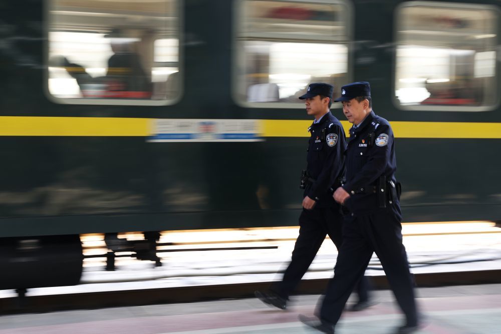3月11日，兰州铁路公安处乘警支队民警段文革（右）和王岳宁在列车开车前巡查。新华社记者　陈斌　摄