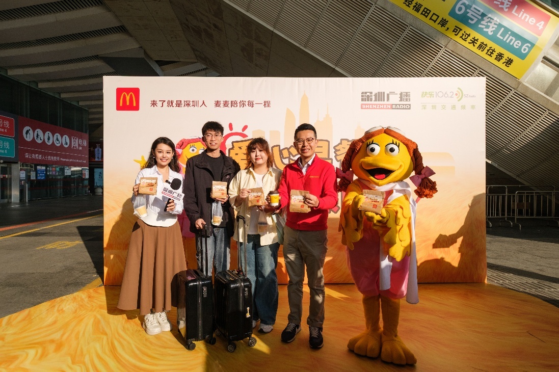首两位领取“爱心早餐”的旅客与麦当劳中国副总裁、深圳市场高级总经理赵崇基（左4）及深圳广播主持人馨竹（左1）合影