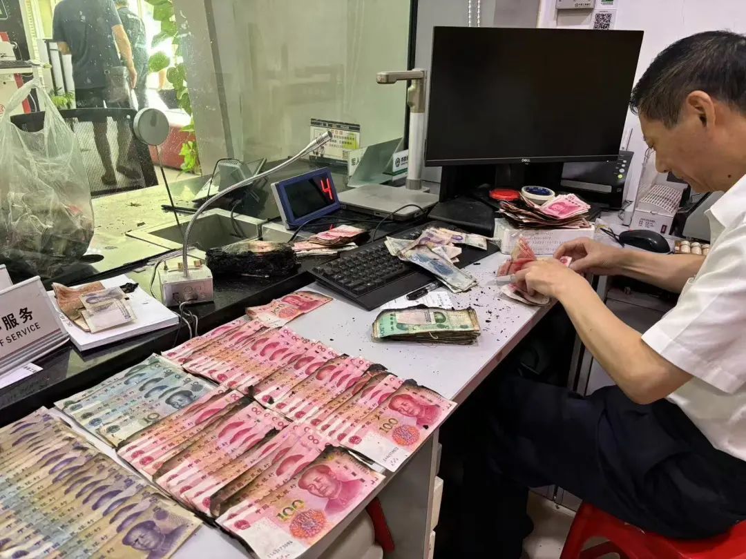 工行武汉新洲支行营业室为客户清点兑换火烧残钞