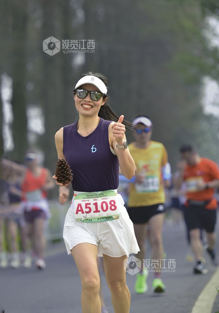 2026年3月15日，南昌半程马拉松开赛，女选手手持松球，自信奔跑于赛道。