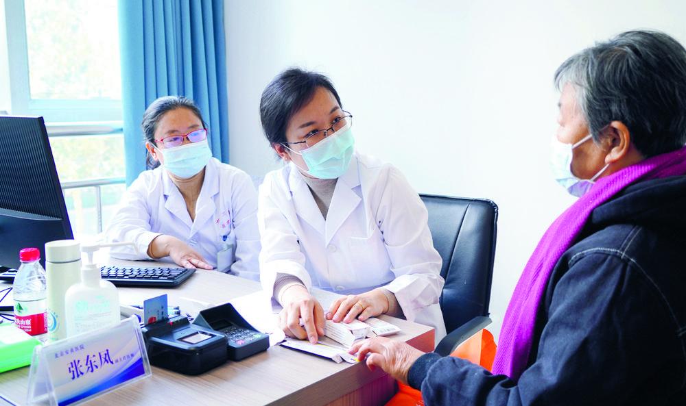 在石家庄市第三医院，来自北京安贞医院的心脏病专家张东凤（中）在为患者诊断。