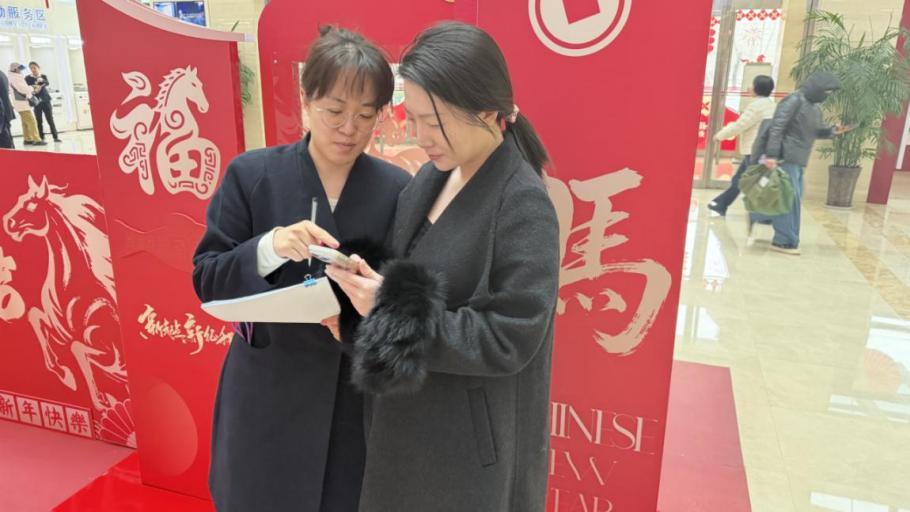 河北中行工作人员在为客户介绍消费满减活动政策。曹菡供图