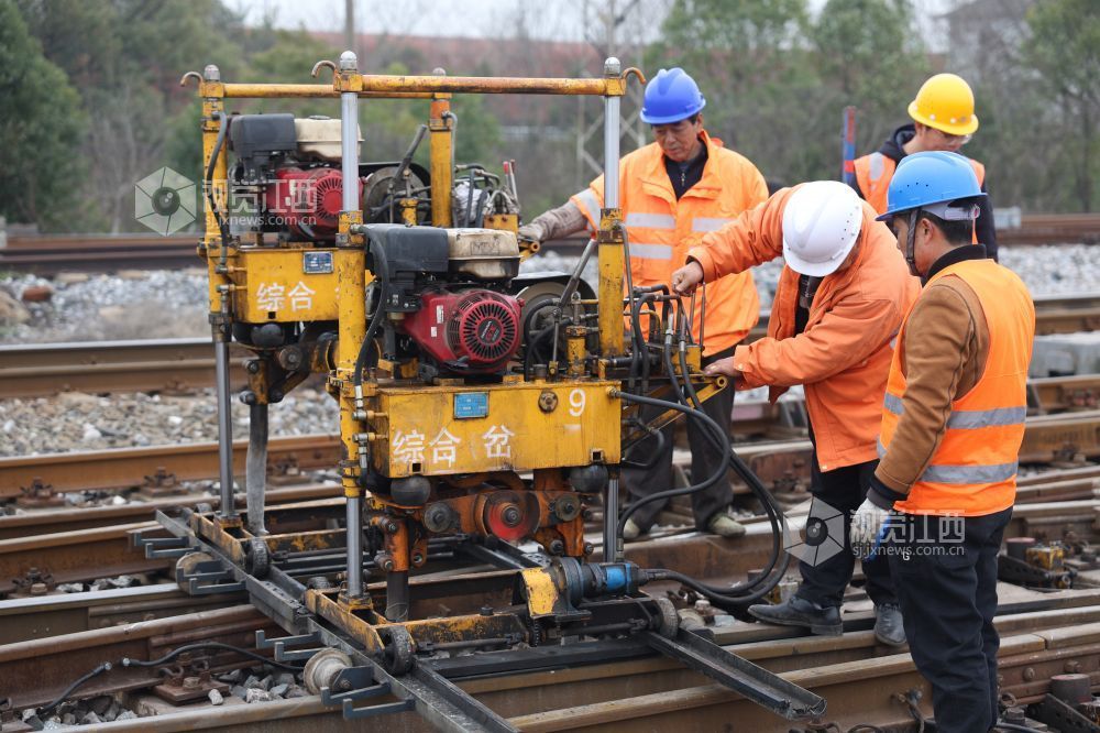 职工正在利用小型液压捣固机对道岔进行捣固作业。 沈文吉 摄