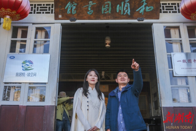 耿达（右）为湖南日报全媒体记者讲述对联背后的故事。
