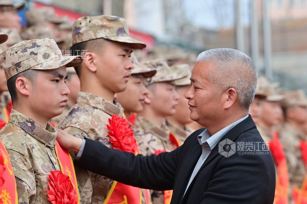 2026年3月15日，江西省宜春市万载县举行2026年上半年新兵入伍欢送仪式，退伍老兵父亲正为即将奔赴军营的新兵儿子整理绶带。