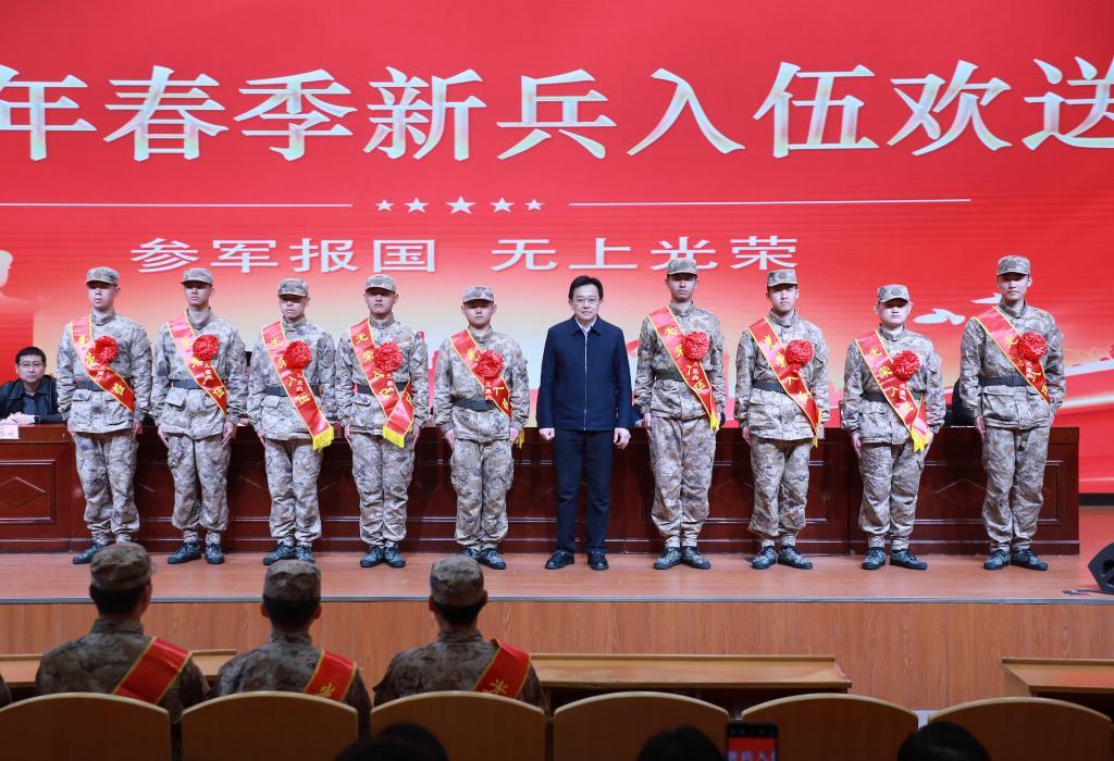 赵光明为入伍学生整理绶带、佩戴大红花‌