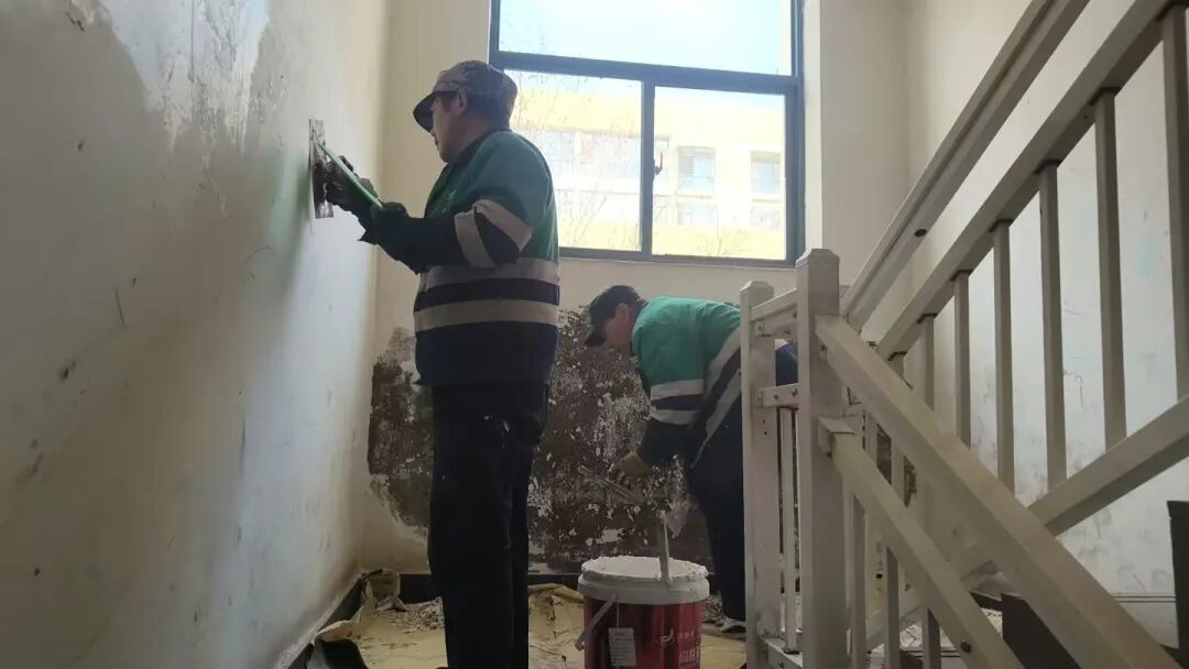 ▲物业工作人员在进行墙皮修补