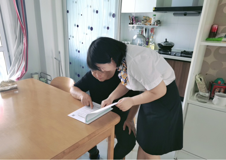 图：滁州分公司客服中心工作人员上门为老年客户讲解保险条款