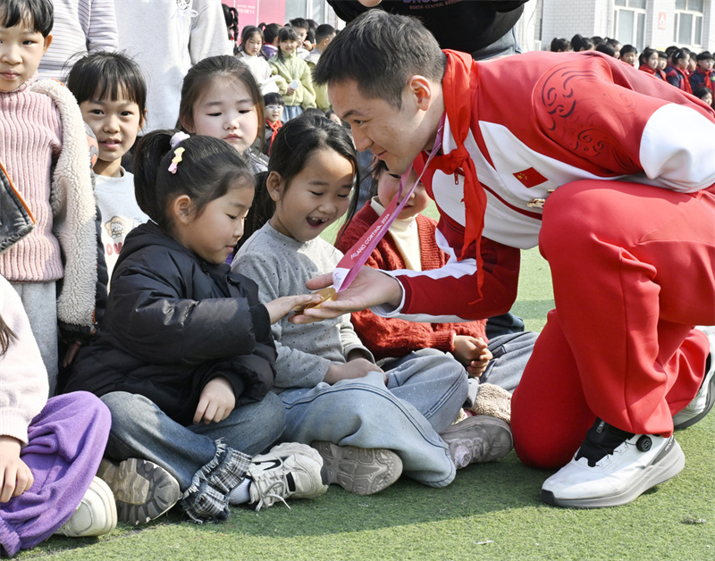 3月20日，纪立家向深泽县耿庄小学的孩子们展示自己获得的金牌。