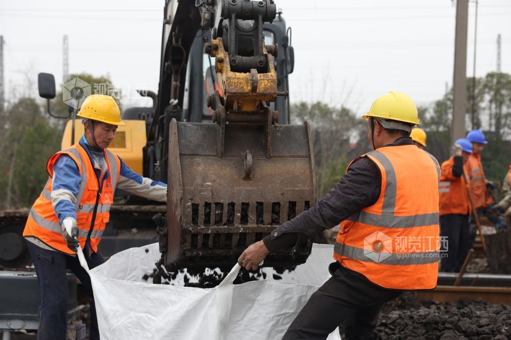 职工正在装卸脏污道砟。 祝路平 摄