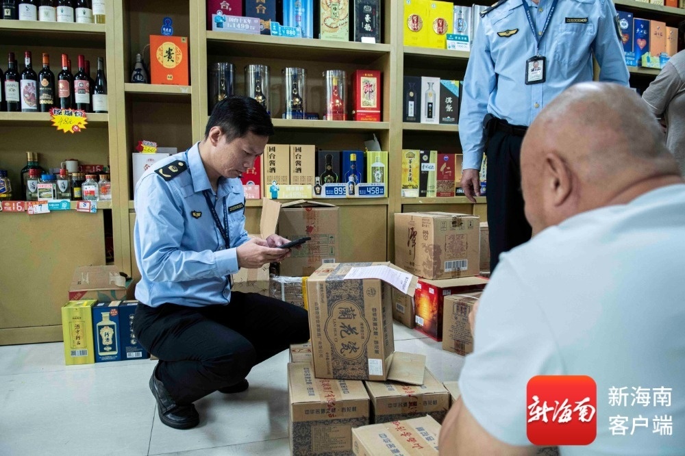 执法人员对涉嫌侵权的白酒进行检查。记者 蒙健 摄