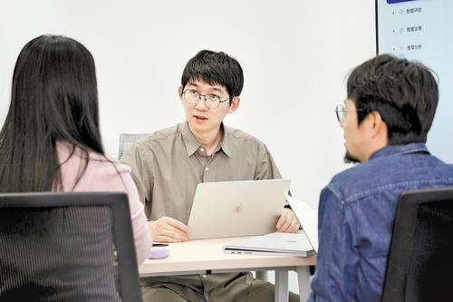 3月17日,稳准智能(雄安)科技有限公司联合创始人兼CEO张天扬与工作人员探讨“极数”数据大模型(LimiX)的优化升级方案。许志才摄