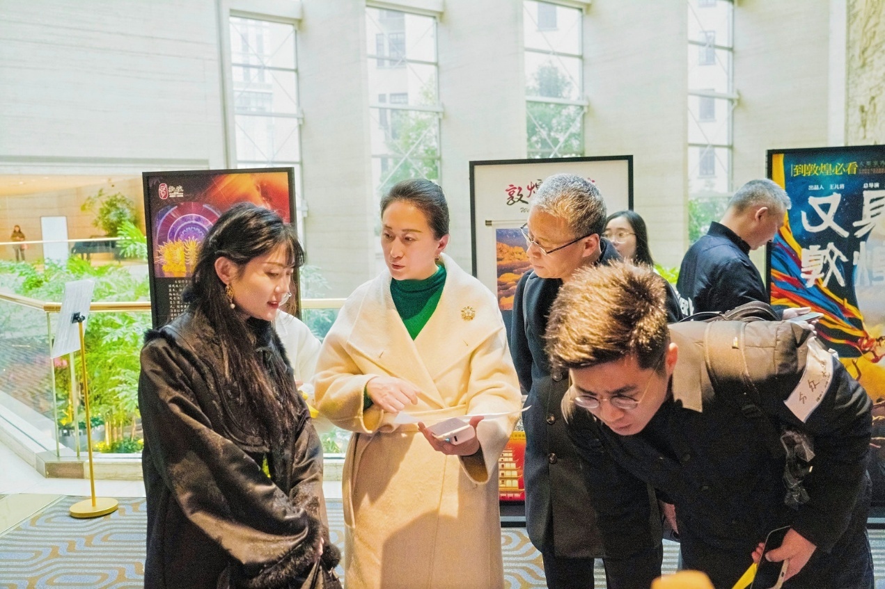 活动现场,嘉宾驻足在展现敦煌优渥文旅资源的展板面前讨论。