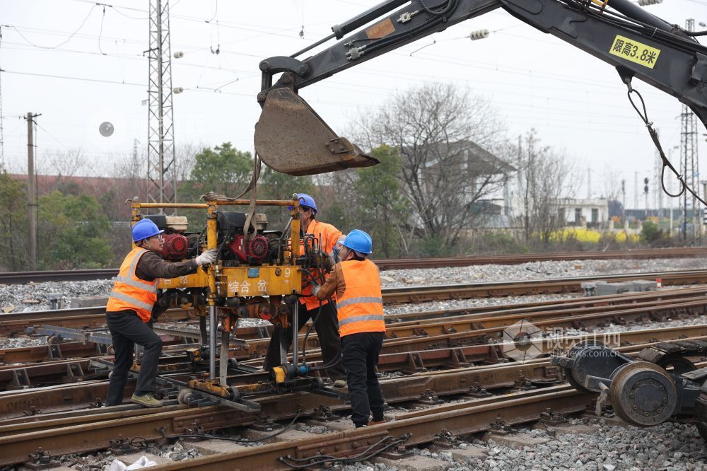 职工正在吊运小型液压捣固机。 沈文吉 摄