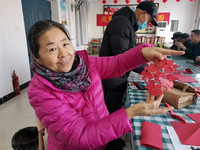 图②　濮阳市华龙区玉兰社区日间照料中心内，物业携手业主开展剪窗花活动。　王伟南 摄