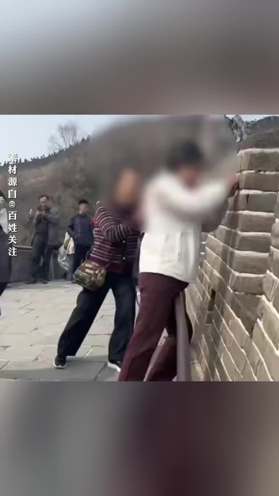 “张某霞二姐妹留念”，女子用剪刀在八达岭长城上刻字