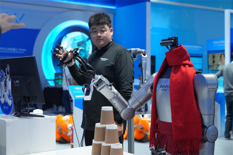 3月26日，在中关村展示中心，工作人员通过力反馈手套操控机器人灵巧手。