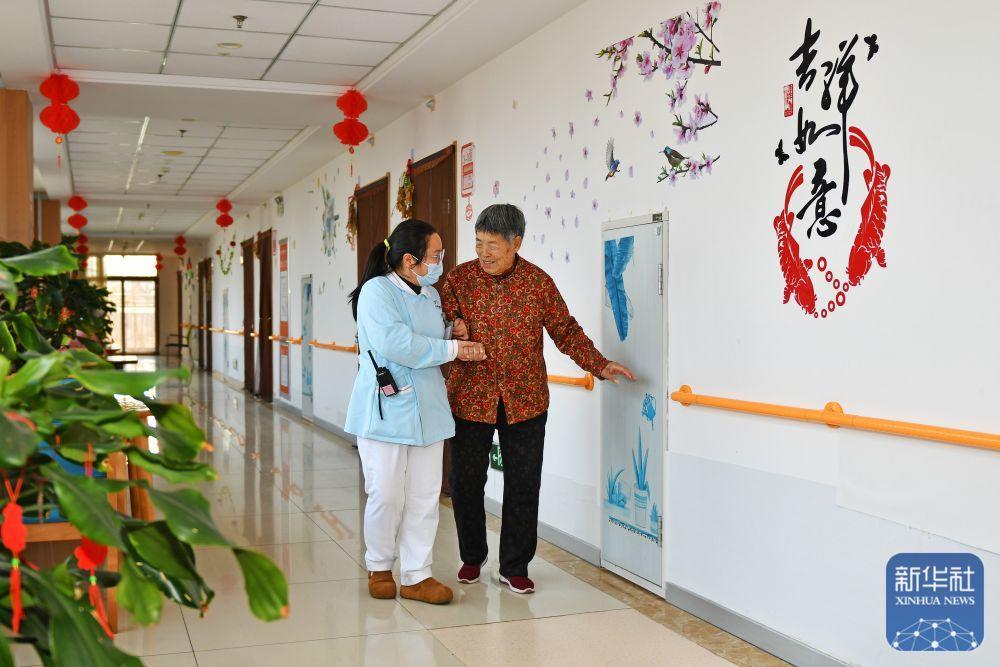 3月23日，在烟台市福山区社会福利服务中心，医护人员陪老人散步聊天。新华社发（孙文潭 摄）
