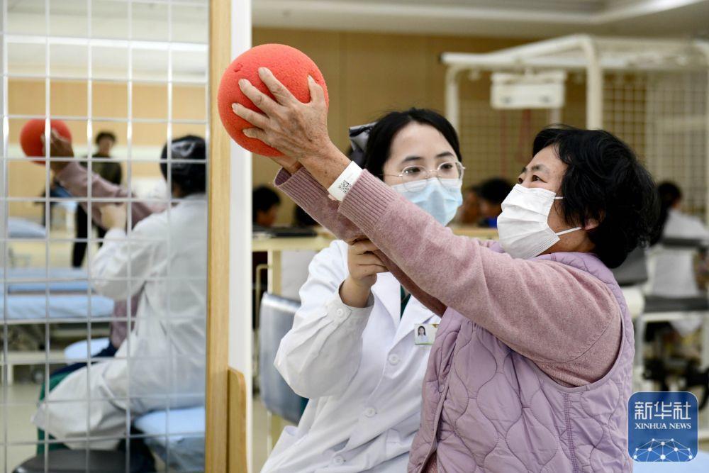3月25日，在日照市康复医院，医护人员协助老人做康复训练。