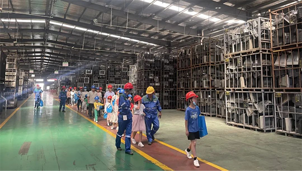 ▲在南昌某电子废物循环利用公司的公众开放活动中，学生走进工厂车间了解电子废弃物变废为宝的过程。