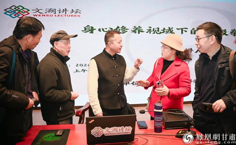 讲座结束后，王岳（中）继续耐心地为意犹未尽围拢过来的太极拳爱好者释疑解惑。