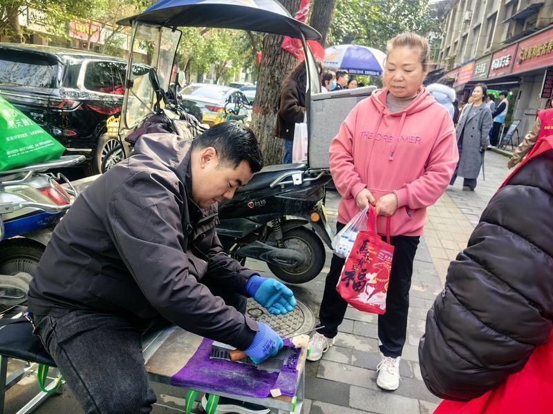 图为张伟为居民义务磨刀(记者 拓玲 摄）