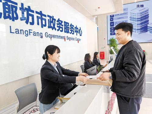 3月26日，在廊坊市政务服务中心“区域通办”专区，市民（右）正在咨询“区域通办”相关事宜。本报记者 刘 杰摄