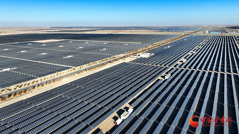 蓝色光伏板在阳光下熠熠生辉,横亘戈壁、阻隔风沙