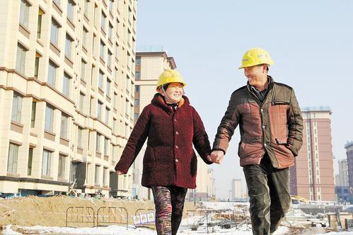 2023年12月26日，雄安新区雄东B单元安置房项目工地，来自安徽宿州的张洪友（右）、葛叶珍夫妇携手走在下工路上。 上海宝冶雄东项目部劳务员 鲁守龙摄