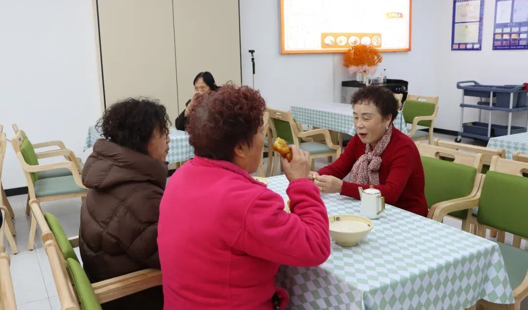△聂良玉和居民们在社区食堂边吃早餐边唠家常
