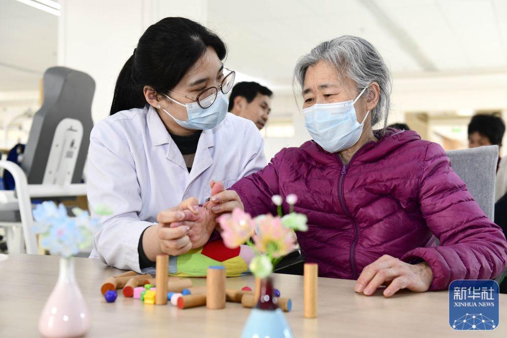 3月25日，在日照市康复医院，医护人员协助老人做康复训练。