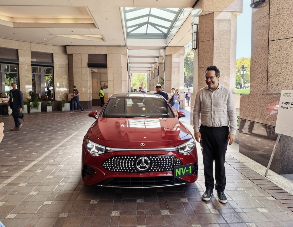 英伟达汽车业务 VP Ali Kani 在试驾车前拍照｜图片来源：极客公园