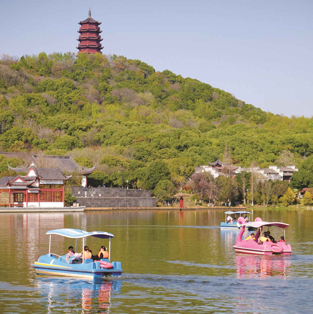 庐陵文化生态园内，湖光映山色，游客乘着脚踏船游玩。 蔡含璐 摄