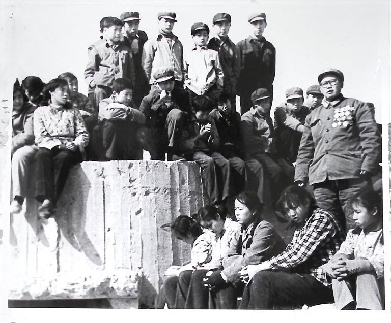 1981年10月陈全魁（右一）同志在当年营盘岭弹痕累累的碉堡残骸前给青年讲述曹德荣烈士的事迹　刘玉璋　摄