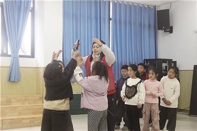 快乐瓷娃音乐公益班的志愿者老师为孩子们上音乐课。 (全媒体记者 王湘琴 摄)