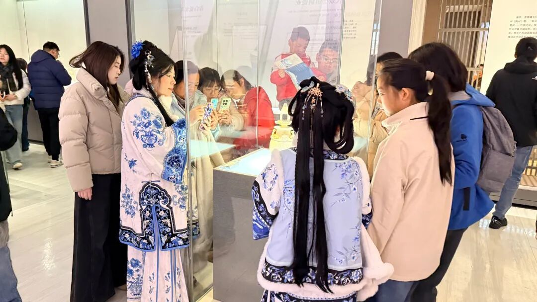 游客在景德镇中国陶瓷博物馆围着展品拍照。图片摄于2026年1月25日