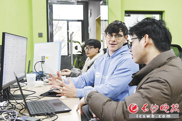 睿森（中）和同事在研究工作中的问题。 长沙晚报全媒体记者 王志伟 摄