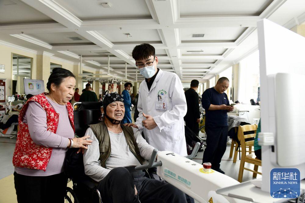 3月24日，在山东省立三院康复护理院，工作人员指导老人进行脑机接口康复训练。